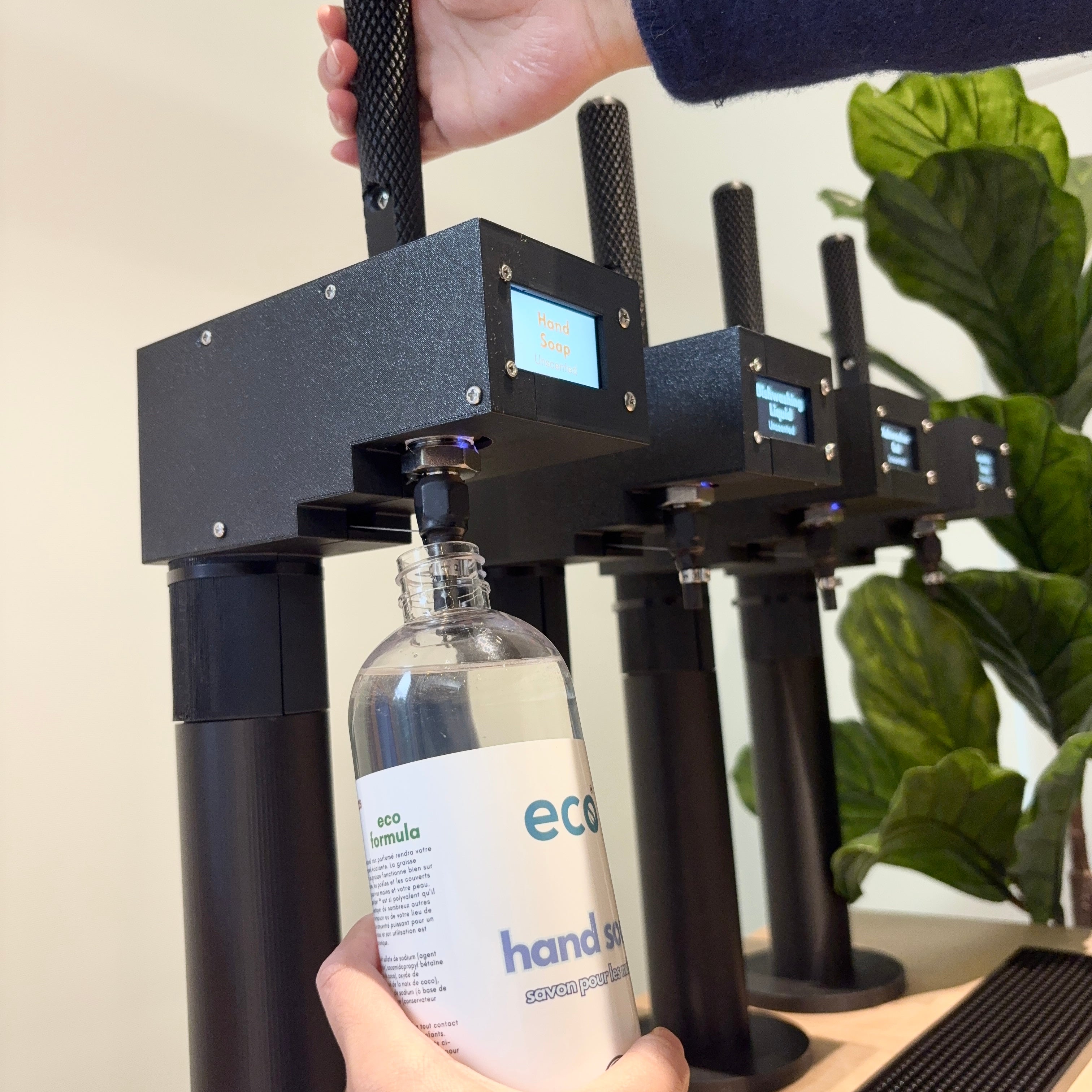 Person refilling hand soap at a refill station.